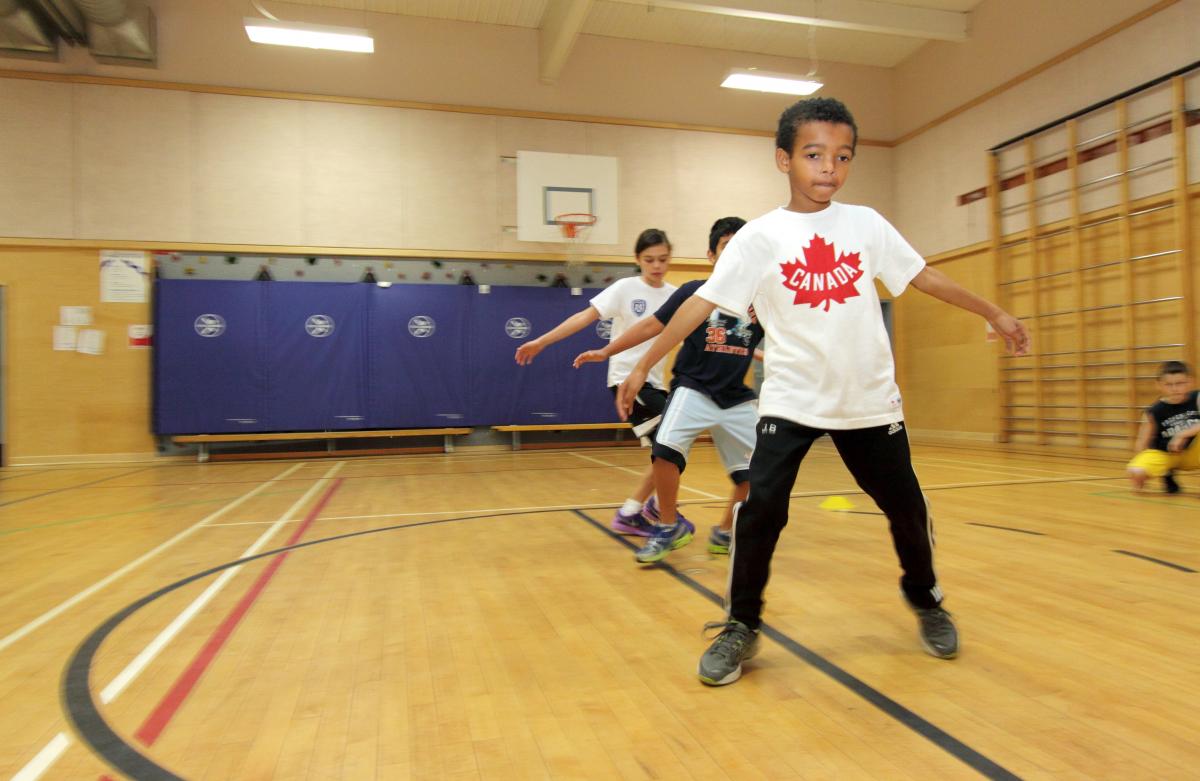 three young children in a line doing crossovers